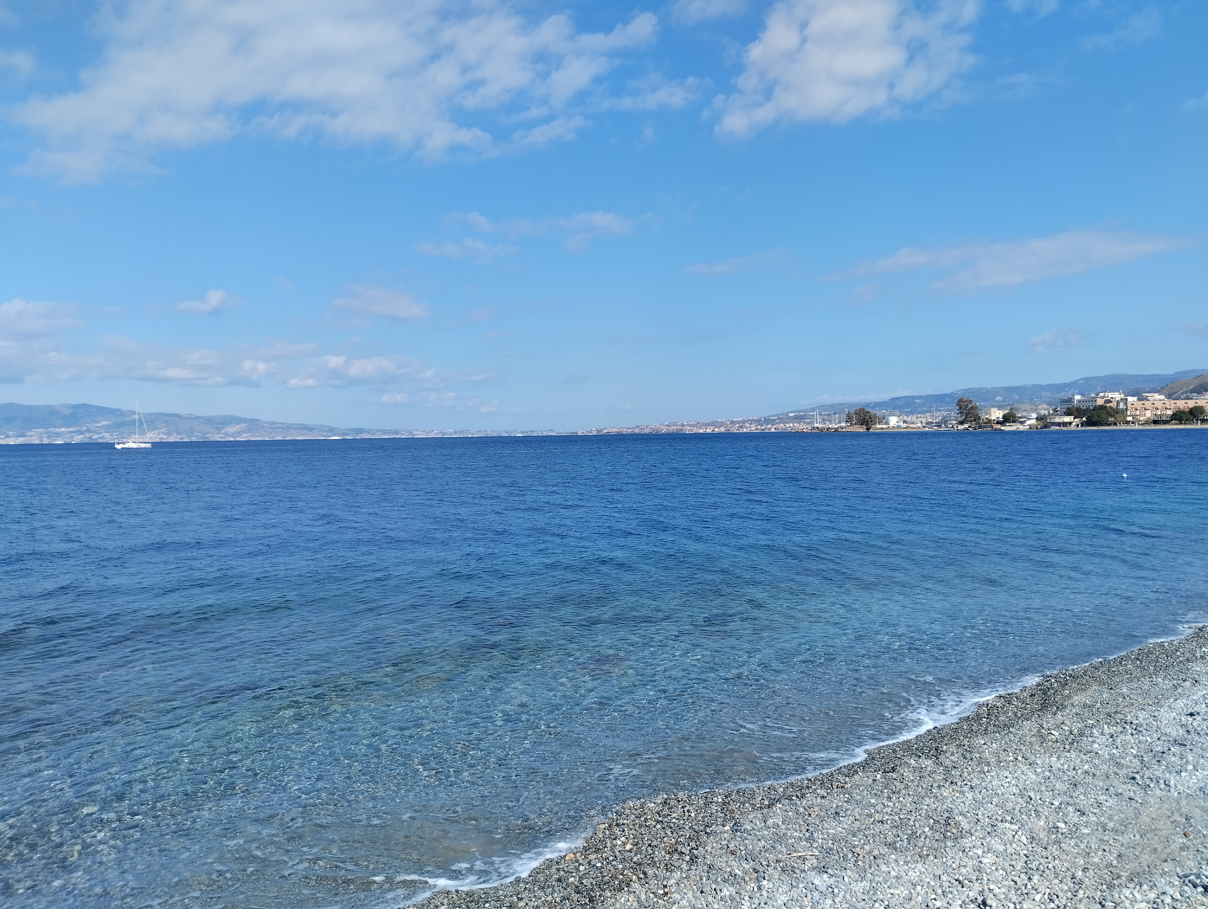 Spiaggia di ghiaia nera di Reggio Calabria con lo Stretto